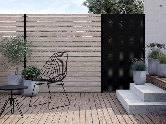 Das Bild zeigt eine Terrasse mit TRIAS Sichtschutz (Rhombus Holz und Alu)
