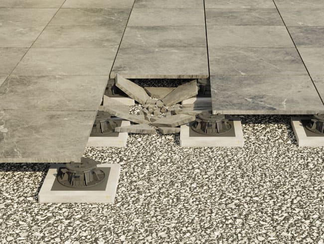 Das Bild zeigt den Bruch einer Terrassenplatte verlegt auf Stelzlagern