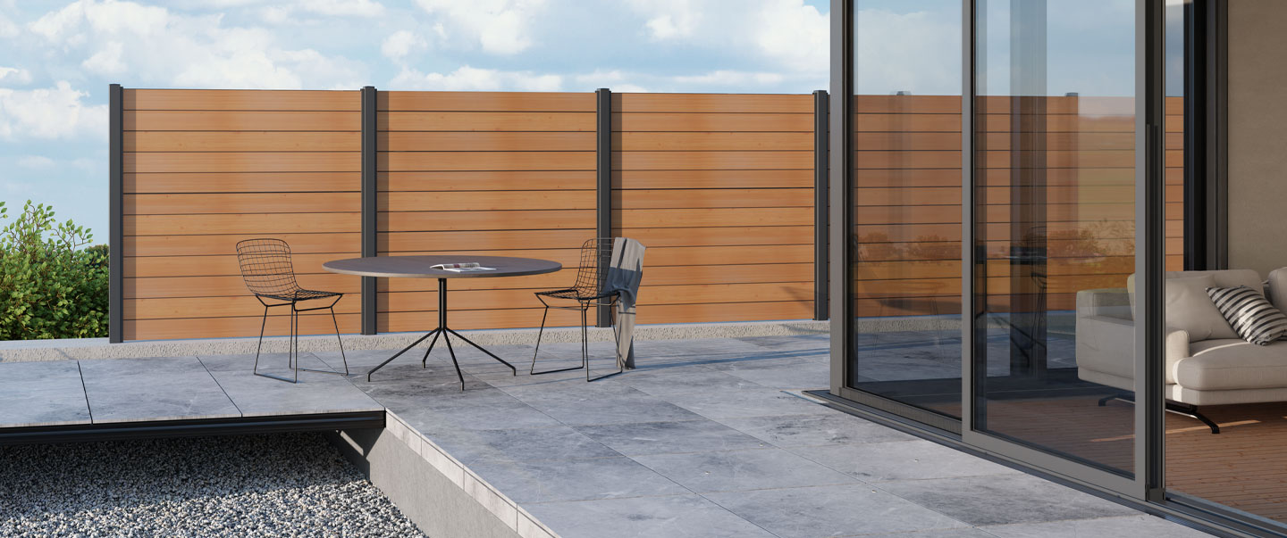 Das Bild zeigt eine Terrasse mit Sichtschutz mit Dielen aus Aluminium in Holzoptik