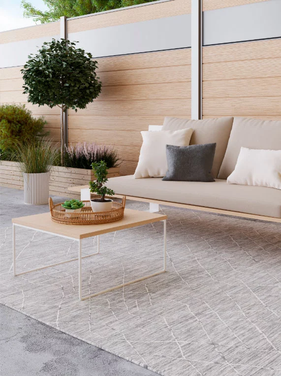 Terrasse mit Outdoorteppich auf grauen Fliesen