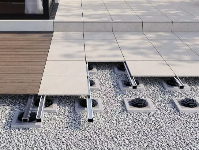 Das Bild zeigt die Terrassen-Unterkonstruktion TRIAS ALU mit Dielen und Platten