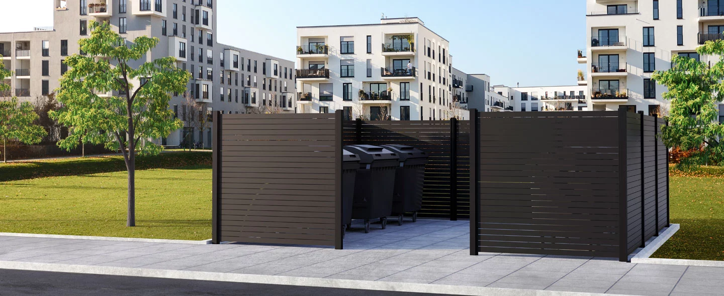 Das Bild zeigt eine Mülltonneneinhausung im Vorgarten von einem Mehrfamilienhaus