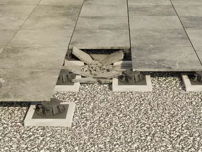 Das Bild zeigt den Bruch einer Terrassenplatte verlegt auf Stelzlagern