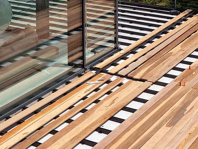 Terrassenbau im Prozess – Holzdielen auf Aluminium-Unterkonstruktion werden fachgerecht verlegt
